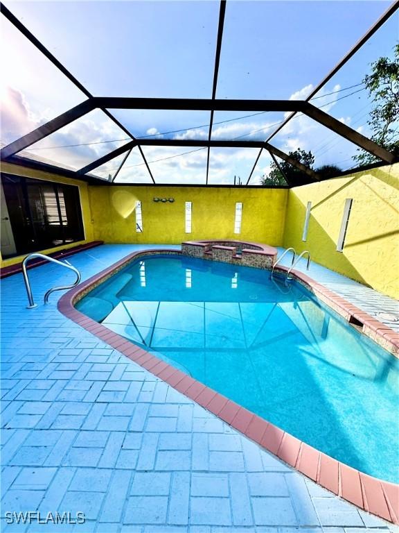 view of swimming pool with an in ground hot tub, a lanai, and a patio area