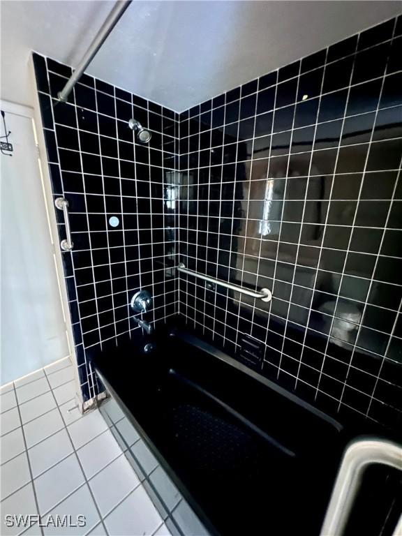 bathroom featuring tiled shower / bath combo and tile patterned flooring