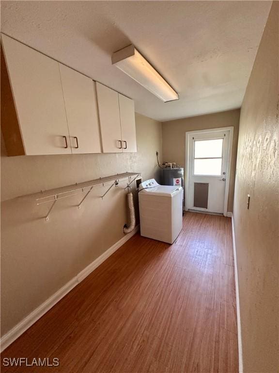 laundry room featuring hardwood / wood-style floors, washer / dryer, and cabinets