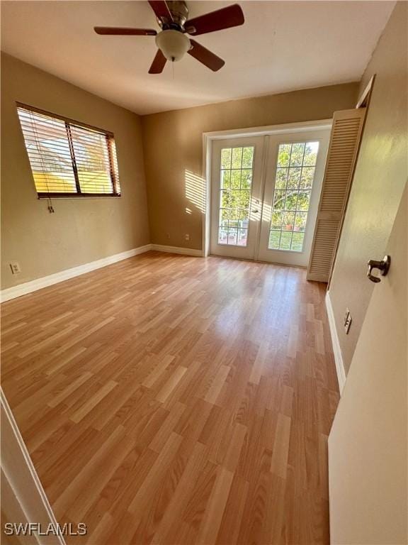 unfurnished room featuring french doors, ceiling fan, and light hardwood / wood-style flooring