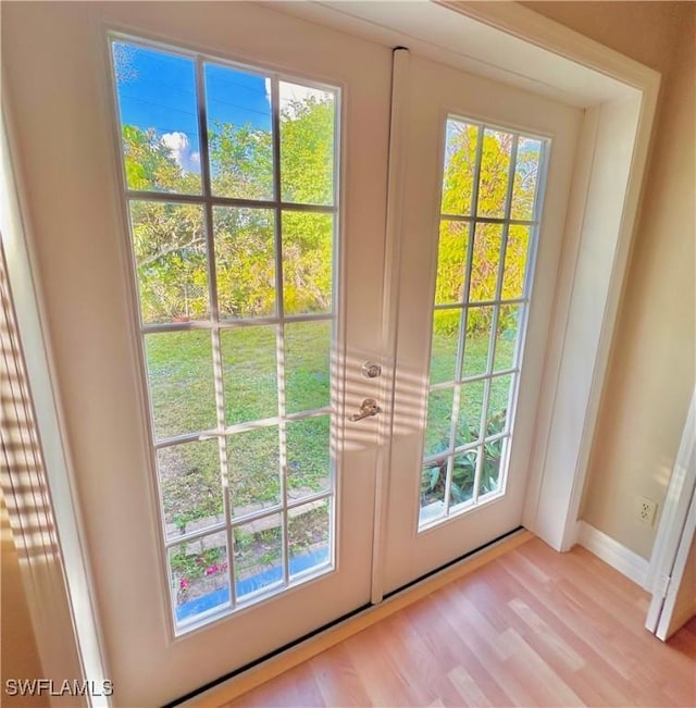 doorway with light hardwood / wood-style floors and french doors