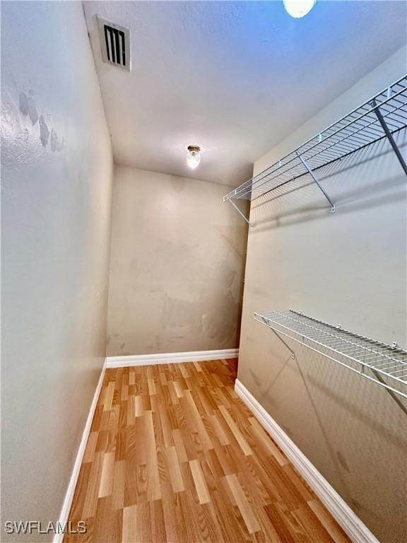 walk in closet with wood-type flooring