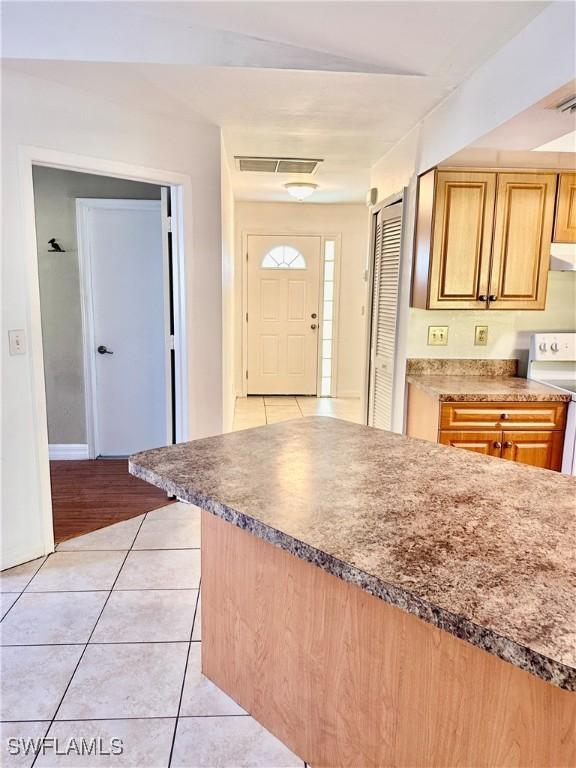 kitchen featuring light tile patterned floors and white electric stove