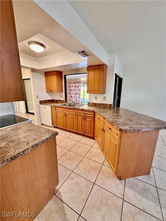 kitchen featuring sink, light tile patterned floors, dishwasher, kitchen peninsula, and a raised ceiling