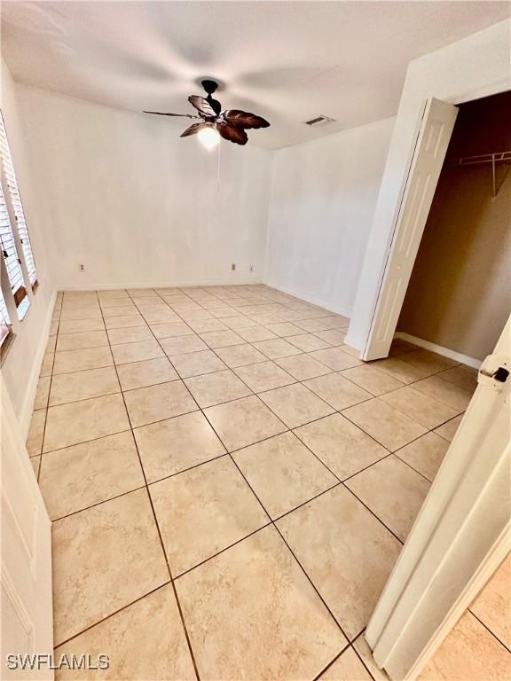 spare room featuring ceiling fan and light tile patterned flooring