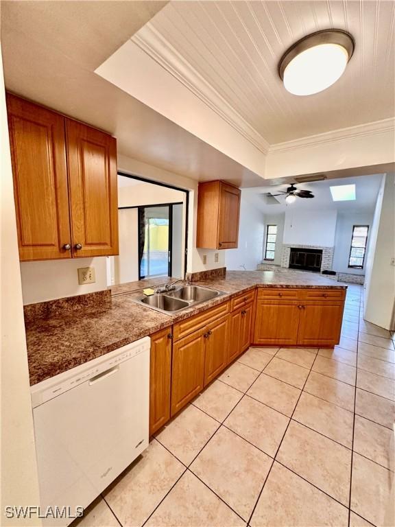 kitchen with sink, crown molding, white dishwasher, a raised ceiling, and kitchen peninsula