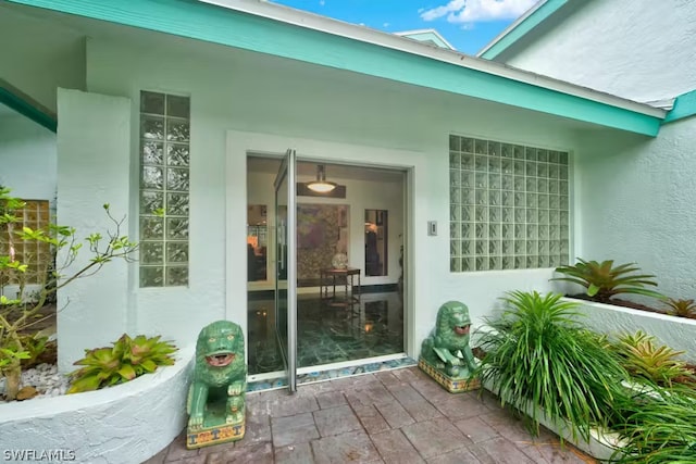 doorway to property featuring stucco siding