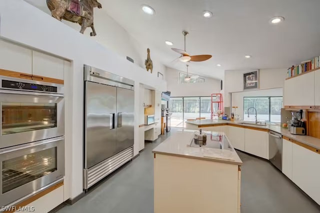 kitchen with white cabinetry, a kitchen island, appliances with stainless steel finishes, and light countertops