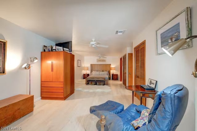 bedroom with light wood-style floors, visible vents, and a closet