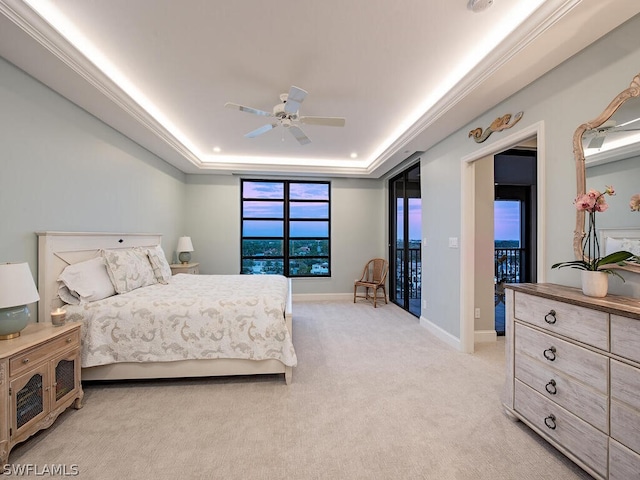 carpeted bedroom featuring access to exterior, ceiling fan, a raised ceiling, and ornamental molding