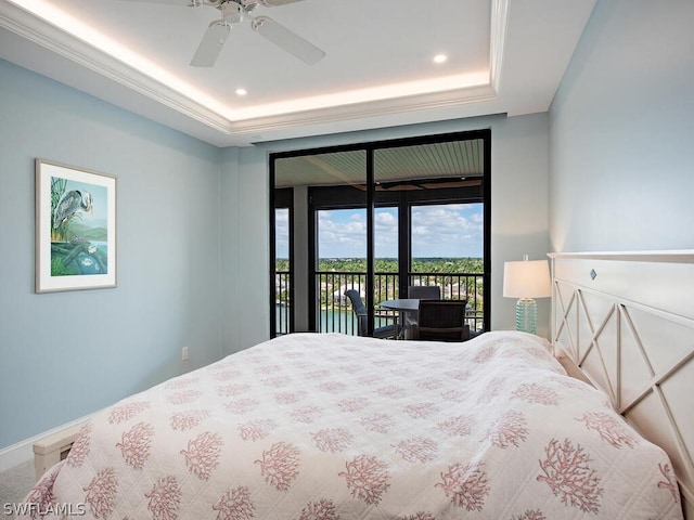 bedroom featuring access to outside, ceiling fan, and a tray ceiling