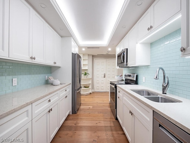 kitchen with stainless steel appliances, white cabinetry, and sink