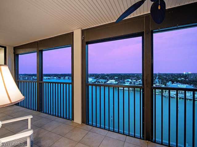 unfurnished sunroom featuring a water view and ceiling fan