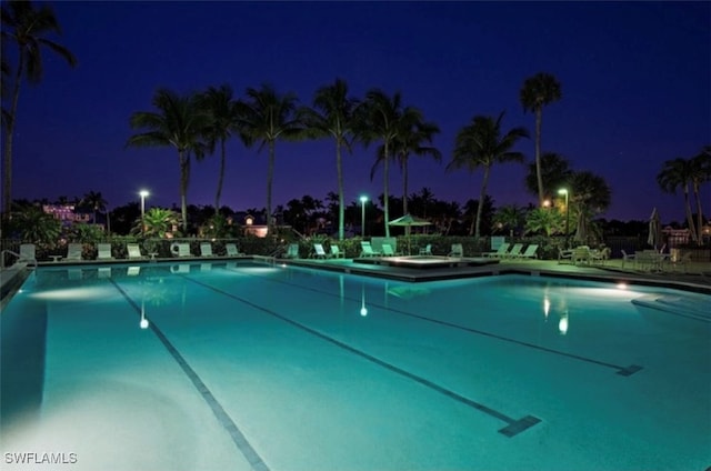 view of pool at twilight