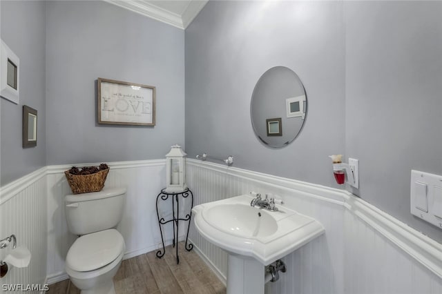 bathroom featuring crown molding, sink, wood-type flooring, and toilet