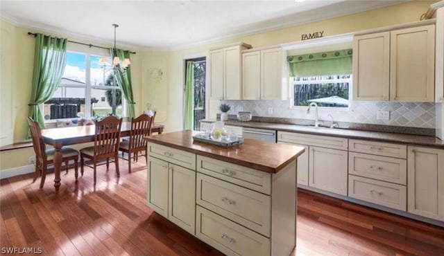 kitchen featuring wooden counters, sink, hanging light fixtures, a wealth of natural light, and dark hardwood / wood-style flooring