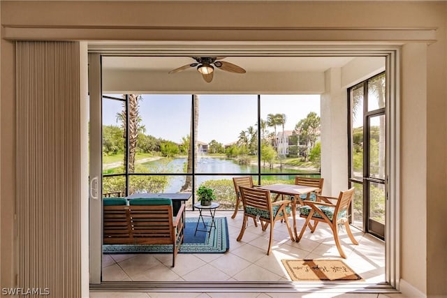 sunroom with a water view, plenty of natural light, and a ceiling fan