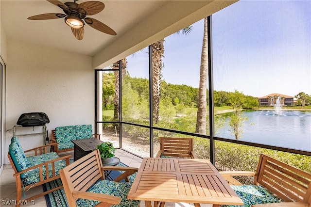 sunroom featuring a water view, plenty of natural light, and a ceiling fan