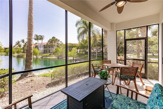 sunroom / solarium featuring a water view and a ceiling fan