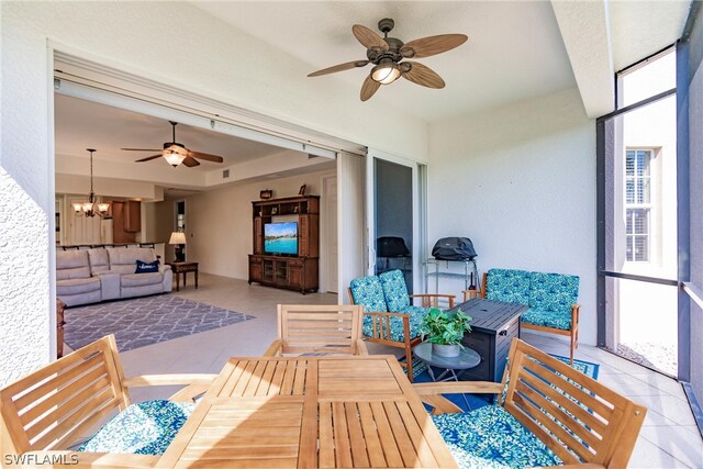 sunroom / solarium with ceiling fan with notable chandelier