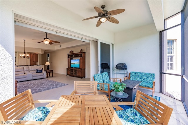 sunroom with ceiling fan with notable chandelier