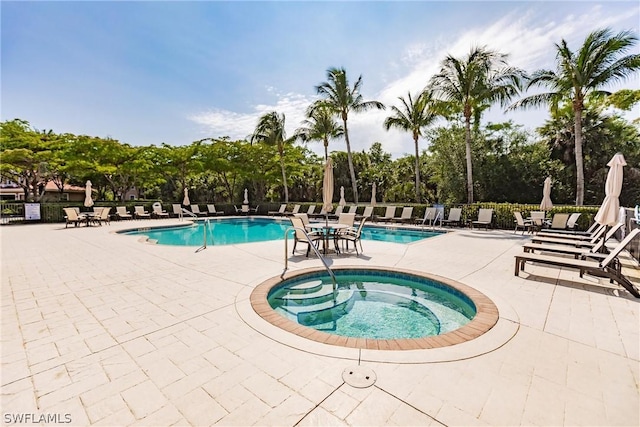 community pool featuring a community hot tub, a patio area, and fence