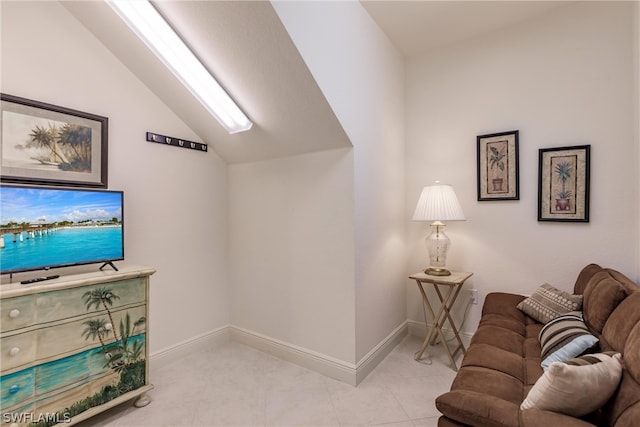 living room featuring light tile patterned floors, baseboards, and vaulted ceiling