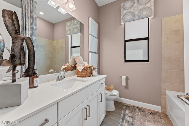 full bathroom featuring toilet, baseboards, wood finished floors, and vanity