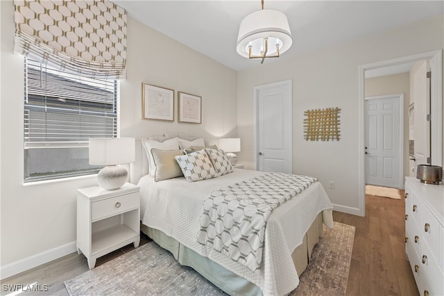 bedroom with wood finished floors and baseboards