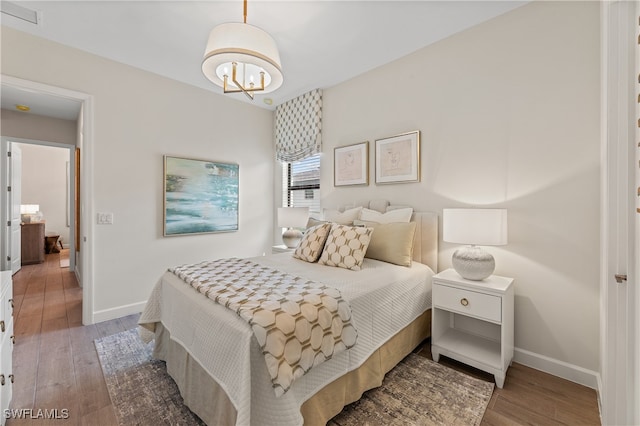 bedroom featuring a chandelier and hardwood / wood-style flooring