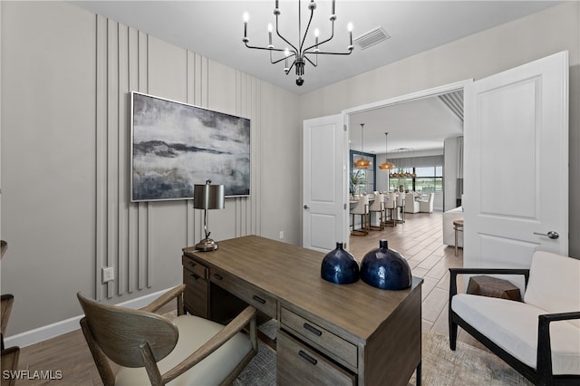 office area featuring baseboards, light wood-style flooring, visible vents, and a notable chandelier