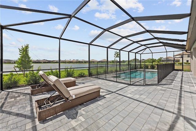 view of pool featuring a water view, a patio, and glass enclosure