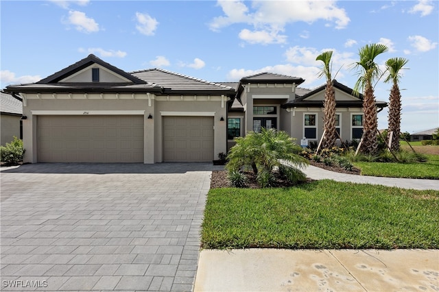 prairie-style house with a garage and a front lawn