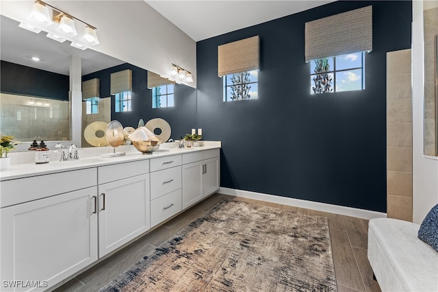 bathroom with double vanity and hardwood / wood-style floors