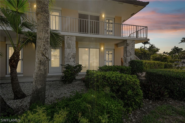 back house at dusk with a balcony