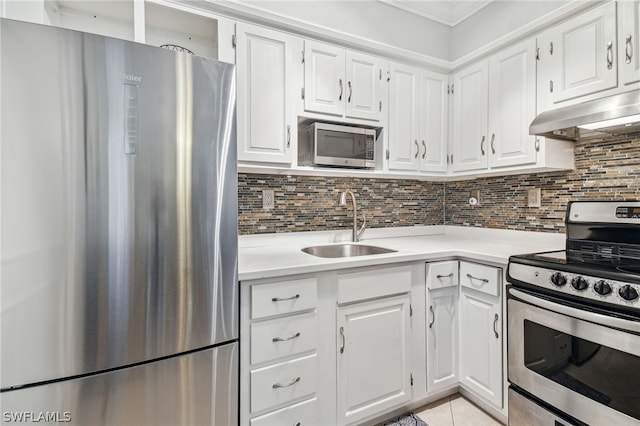 kitchen with white cabinets, decorative backsplash, stainless steel appliances, and sink