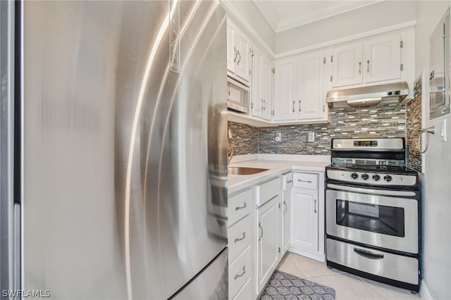 kitchen featuring light tile patterned floors, white cabinets, range hood, and appliances with stainless steel finishes