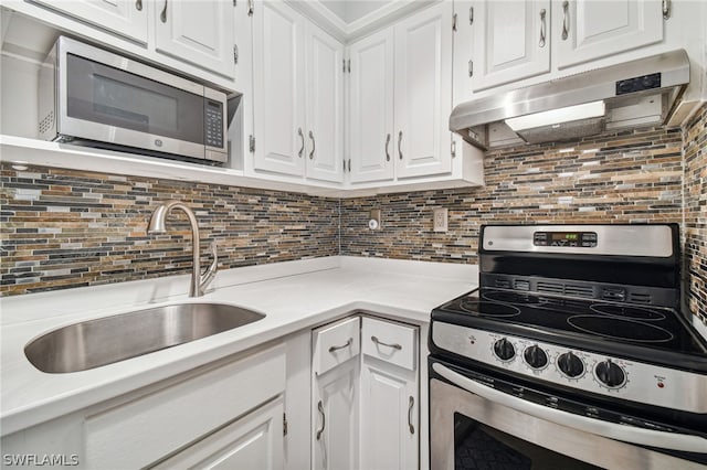 kitchen with decorative backsplash, white cabinetry, sink, and appliances with stainless steel finishes