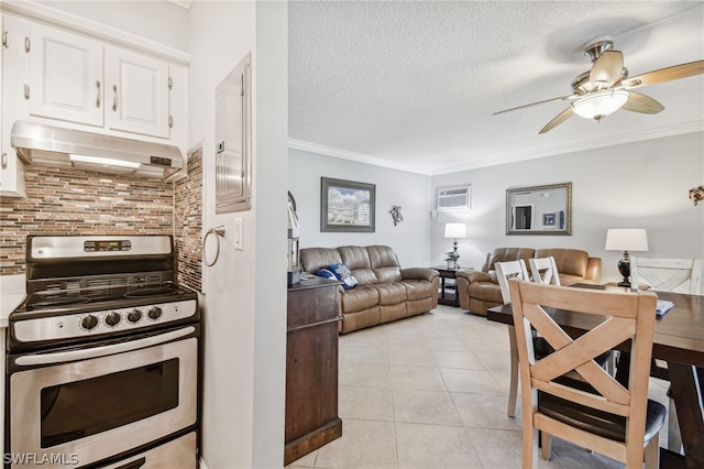 kitchen with a textured ceiling, crown molding, stainless steel range oven, white cabinets, and light tile patterned flooring