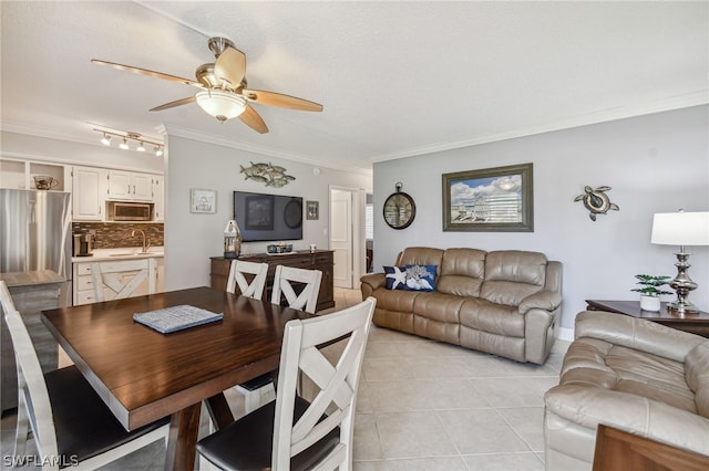 tiled dining space featuring a textured ceiling, ceiling fan, ornamental molding, and sink