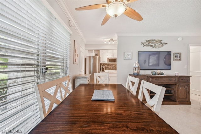 tiled dining room with ceiling fan, ornamental molding, a textured ceiling, and a wealth of natural light