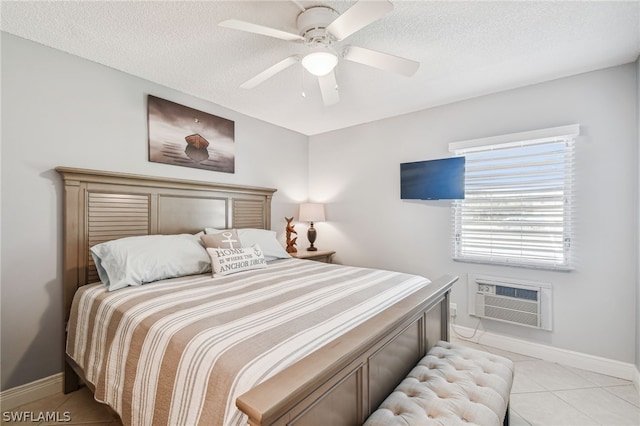 tiled bedroom featuring a textured ceiling, a wall unit AC, and ceiling fan