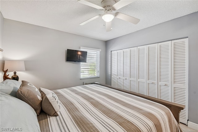 bedroom featuring ceiling fan, a closet, and a textured ceiling