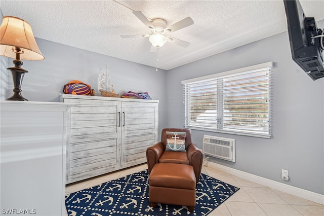 living area with ceiling fan, light tile patterned floors, a textured ceiling, and a wall unit AC