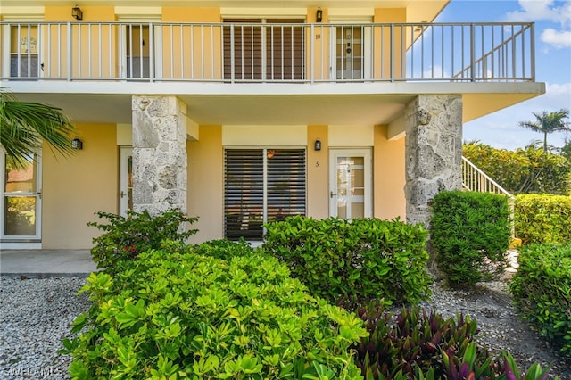 view of exterior entry featuring a balcony