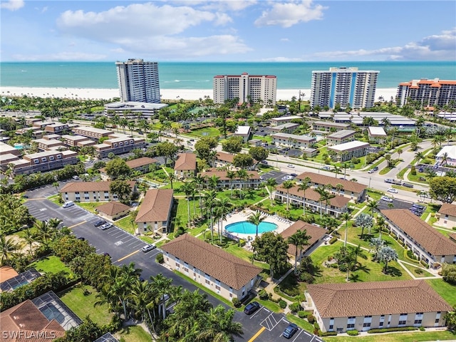 birds eye view of property featuring a water view and a beach view