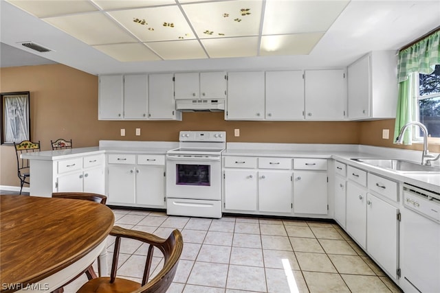 kitchen with light tile floors, sink, white appliances, white cabinetry, and kitchen peninsula