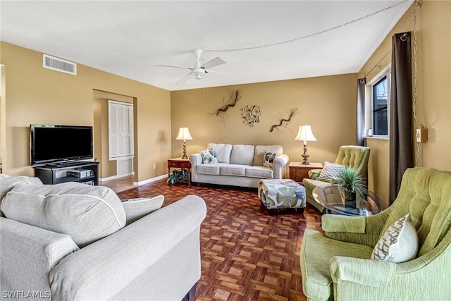 living room with a textured ceiling, ceiling fan, and dark parquet flooring