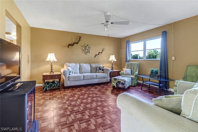 living room featuring parquet flooring, ceiling fan, and a textured ceiling