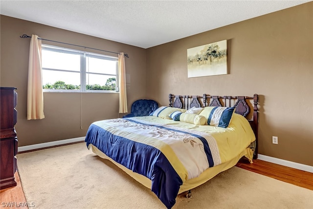 bedroom with wood-type flooring and a textured ceiling